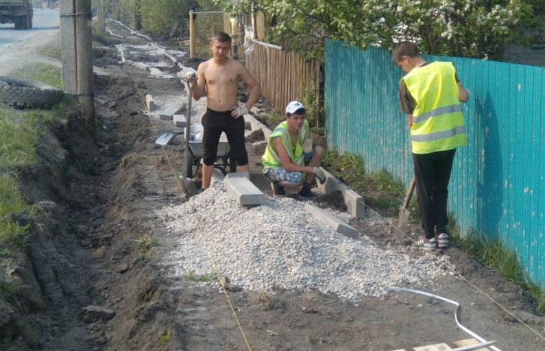 На ул. Советской подрядчик выставляет бордюрные камни и укладывает водопропускные трубы