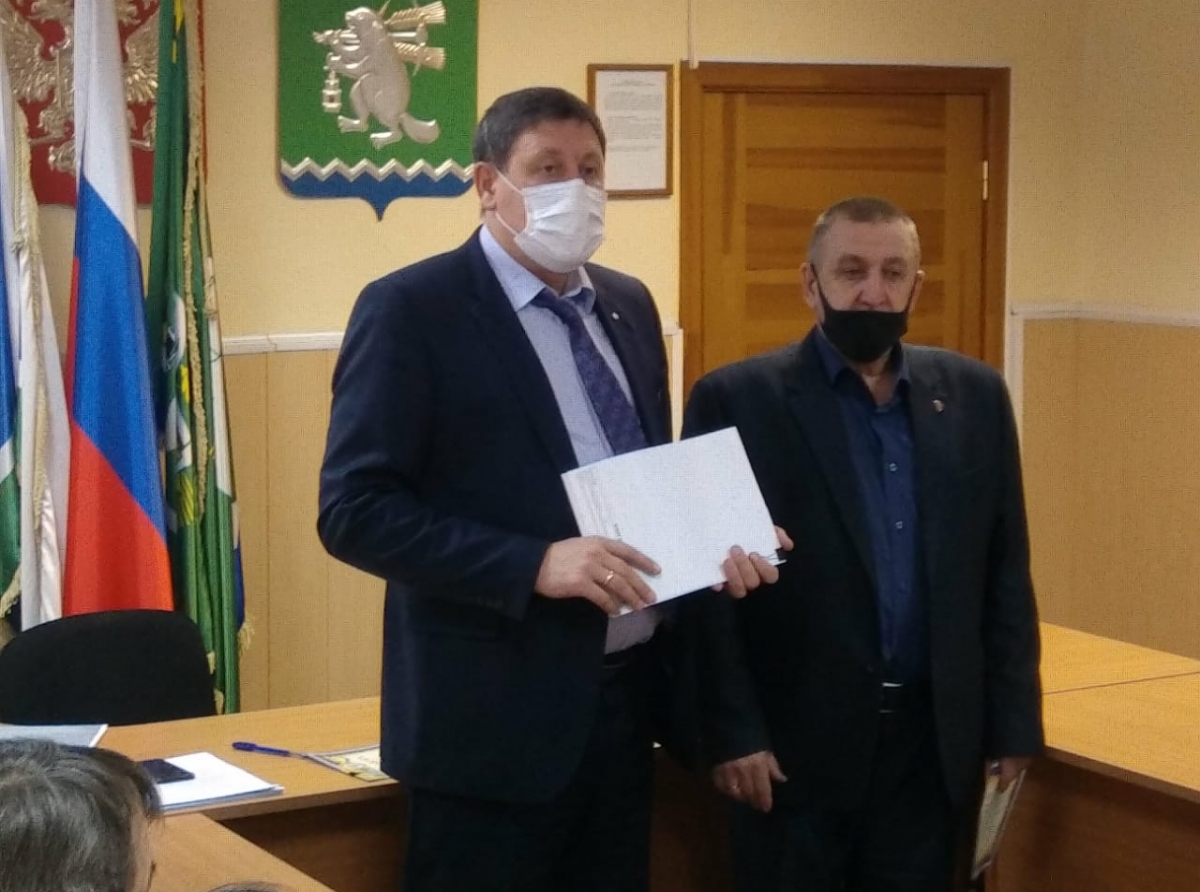 Фото Василия Ергашева. Глава АГО Константин Трофимов вручает награду начальнику ТУ п. Незевай