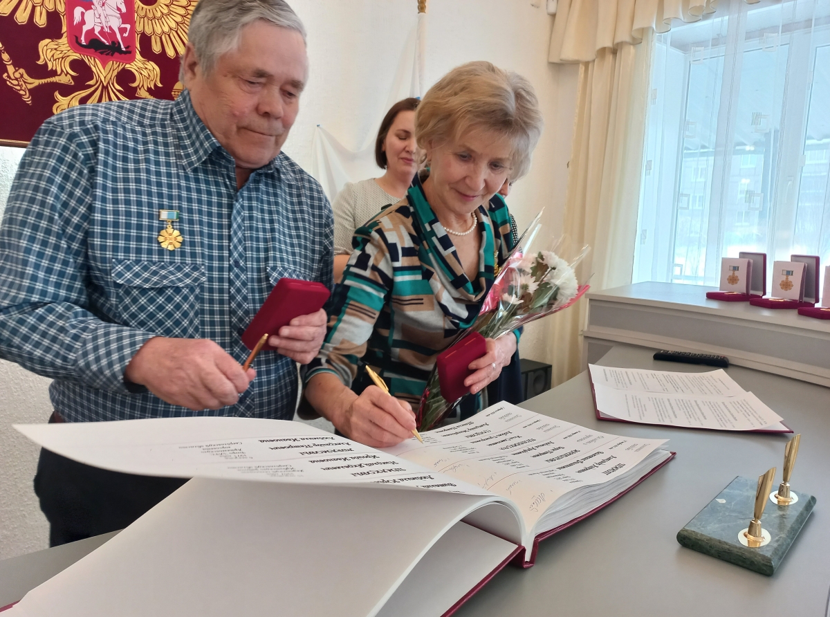 Фото Галины Таскиной. Волнительный момент. Супруги расписывают в книге юбиляров.